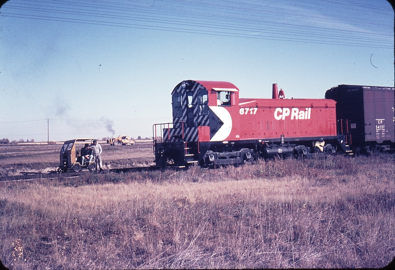 110291: Mile 169 Brooks Sub. AB CIL Spur Seated on Speeder Rdm Jim Anderson and Standing Asst Rdm Carmino Valerio also 6717 Switcher