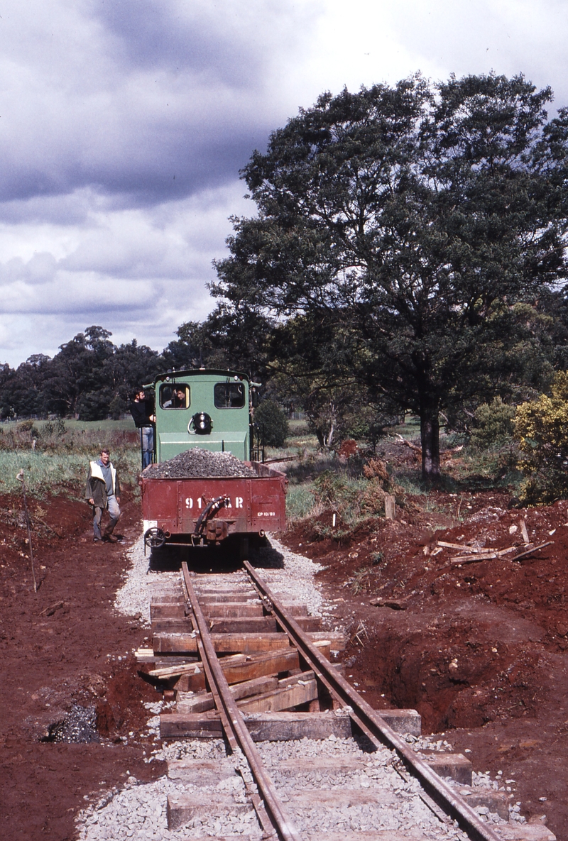 118644: Gembrook Main Road Level Crossing Up Ballast NRT 1 propelling MMBW Pipe Crossing in foreground