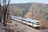 133339: Upper Ferntree Gully (up side), Suburban from Belgrave 3-car X'Trapolis 913 M leading Trees burnt by Black Saturday Fire